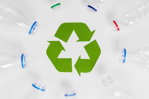 Empty plastic bottles around recycling icon
