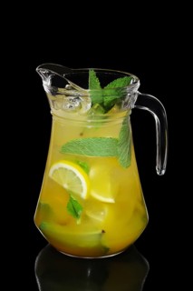 Cold Lemon and mint cocktail with a sparkling wine with ice cubes in pot isolated on black