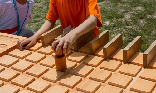 Hand holding wooden puzzle element in hand