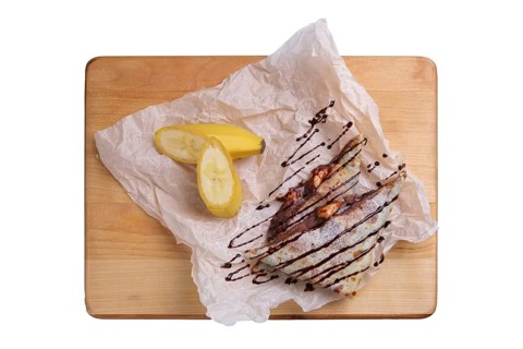 Thin pancakes stuffed with banana and soft cheese isolated on white
