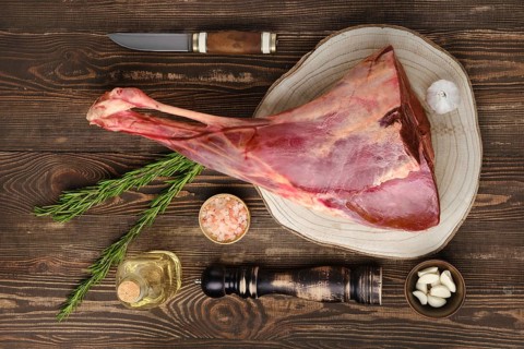 Raw fresh young beef leg on wooden background