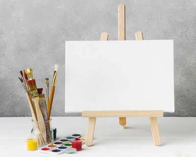 Canvas easel glass filled with paint brushes