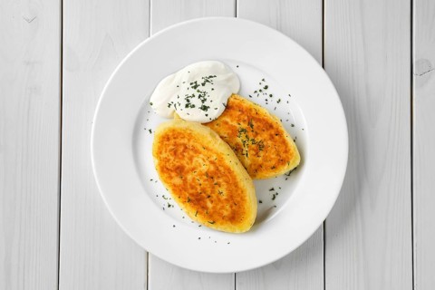 Top view of traditional belarussian potato cakes with sour cream