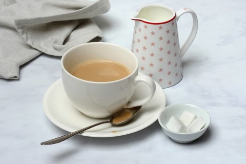 Cup of coffee and pot of milk