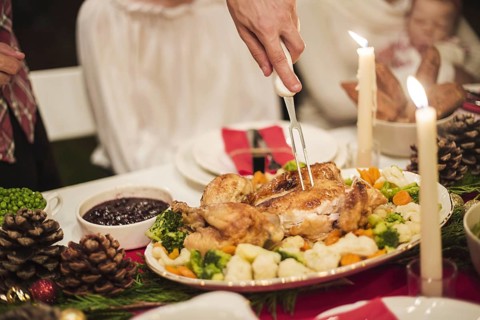 Hand holding turkey with fork christmas table