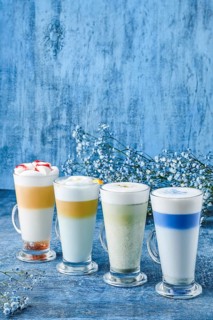 Variations of matcha green tea and chai on blue shabby background