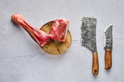 Overhead view of raw fresh deer shank with spice and herb over concrete background