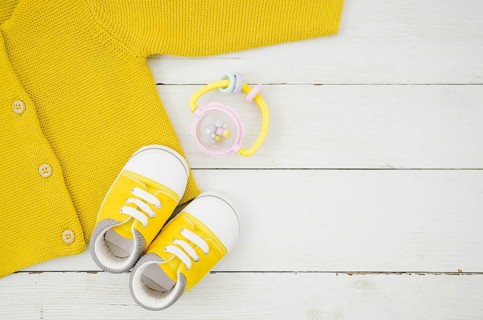 Flat lay baby clothes with wooden background