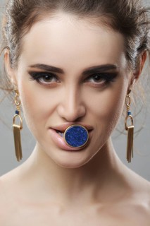Portrait of beautiful fashion model with finger ring with big stone in her mouth. Fresh skin and natural makeup
