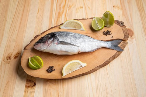 Fresh raw dorada on wooden cutting board