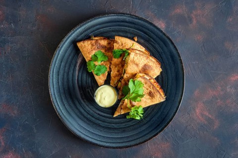 Top view of roasted pita bread stuffed with vegetables and fish
