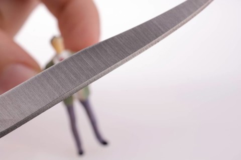 Hand holding a pocket knife near a human figure on a white background