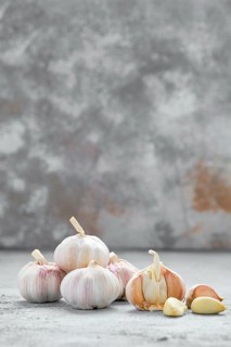 Garlic cloves and bulbs on wooden cutting board