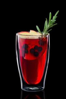 Double-walled glass with hot currant mulled wine isolated on black