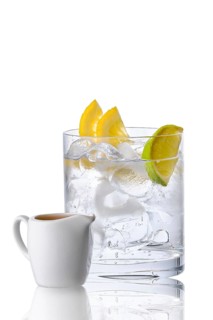Glass with tonic and ice served with espresso in porcelain jug isolated on white background