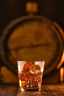 Cocktail old fashioned with barrel on background