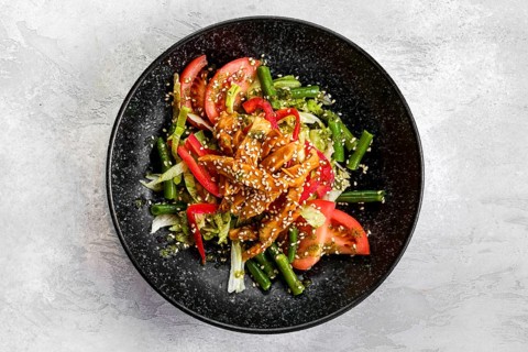 Top view of salad with chicken and teriyaki sauce