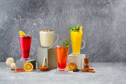 Composition with hot fruit and herbal winter drinks on shabby grey background