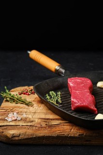 Raw boneless beef tri-tip steak on cast iron skillet