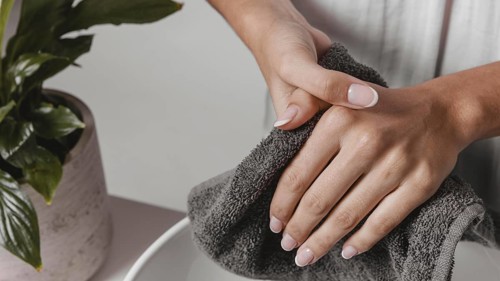 Person drying her hands towel close up