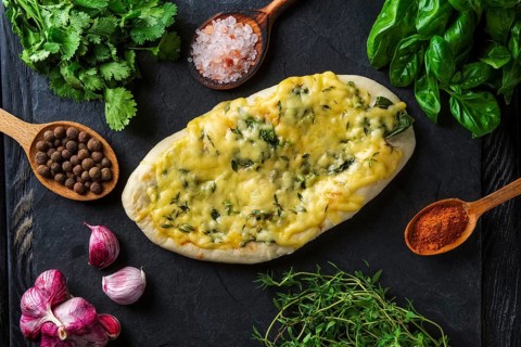 Tasty pita bread baked with herbs and spice surrounded with ingredients
