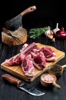 Fresh raw rack of lamb on cutting board with spice
