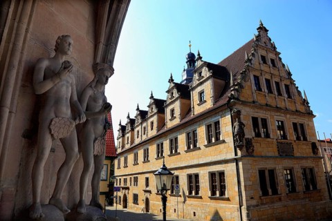 The figures of Adam and Eve on the main portal of the church of St. Moritz and the building of the Casimirianum grammar school