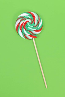 Lollipop with Christmas colors on green background