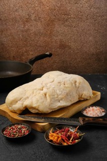Lamb fat tail on kitchen table with salt and pepper