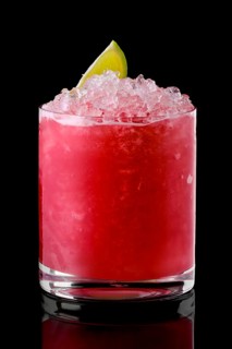 Glass of cold cranberry cocktail with crushed ice isolated on black background