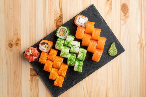 Set of rolls with wasabi and pickled ginger on stone serving board