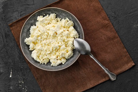 Top view of plate with homemade cottage cheese with spoon
