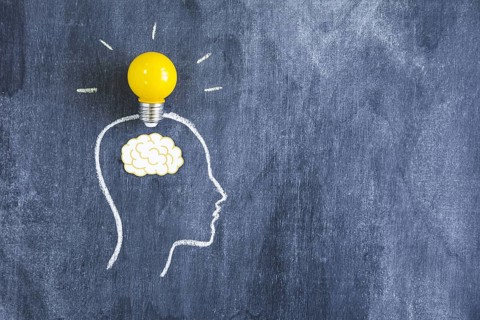 Yellow light bulb paper cutout brain outline face made with chalk blackboard. Resolution and high quality beautiful photo