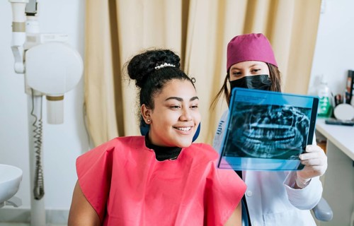 Dentist with patient reviewing the x-ray. Patient looking at x-ray with dentist