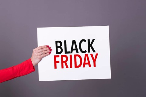 Female hand holding a black friday poster. Studio shot