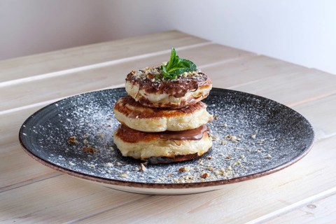 Fritters with peanut butter. Traditional Slavic pancakes with chocolate paste