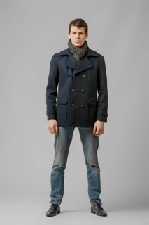 Full length portrait of handsome man in warm woolen coat posing in studio