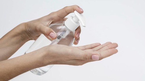 Person pouring liquid soap from bottle with copy space