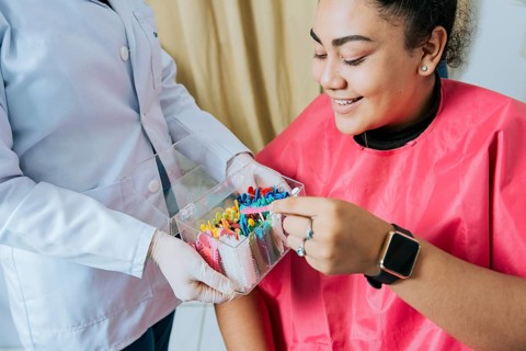 Female patient with dentist choosing dental braces