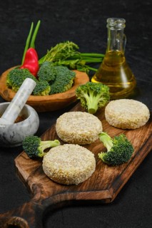 Semifinished homemade chicken cutlet with broccoli on a wooden serving board