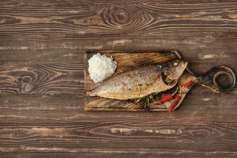 Baked sea yellow tailed mackerel on wooden cutting board