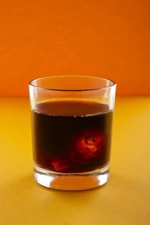 Cola with ice on orange background