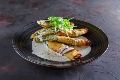 Thin pancakes stuffed with arugula and cheese