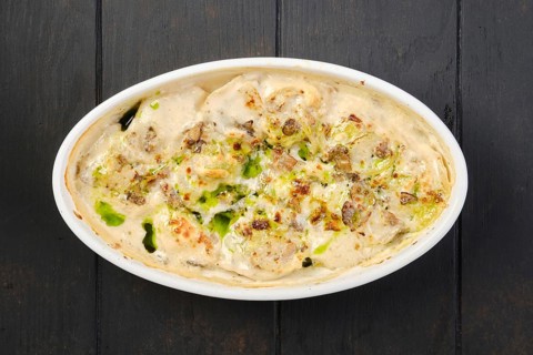 Overhead view of chicken dumplings with spicy onion sauce baked in oven