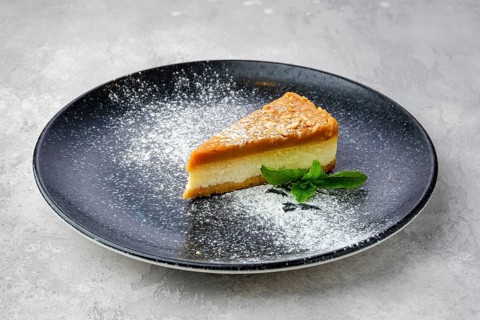 Triangular piece of caramel cheese cake on a plate