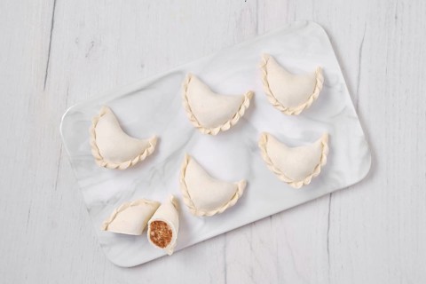Top view of frozen dumplings stuffed with beef meat and provencal herbs on marble serving plate