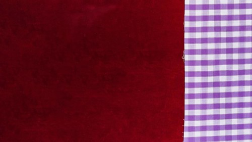 Elevated view chequered pattern textile plain burgundy fabric