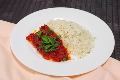 Fried with spices white sea fish served with rice and dill