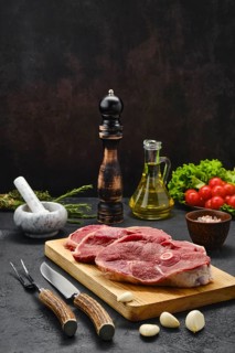 Lamb steaks with spice and knife and fork with horn handle