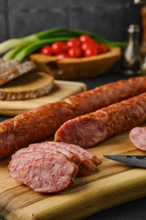 Closeup view of smoked lamb sausage rings on wooden cutting board on kitchen table